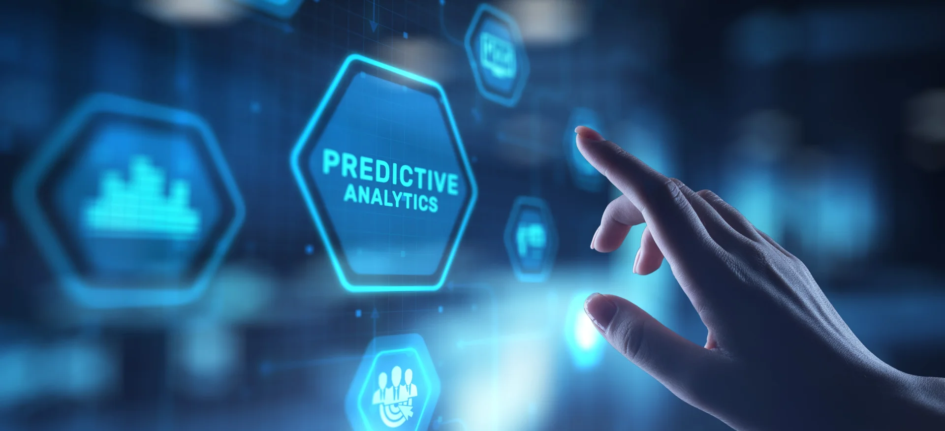 A hand pointing toward a glowing blue hexagonal digital interface button labeled 'PREDICTIVE ANALYTICS,' surrounded by other data-themed icons in a high-tech, futuristic environment.