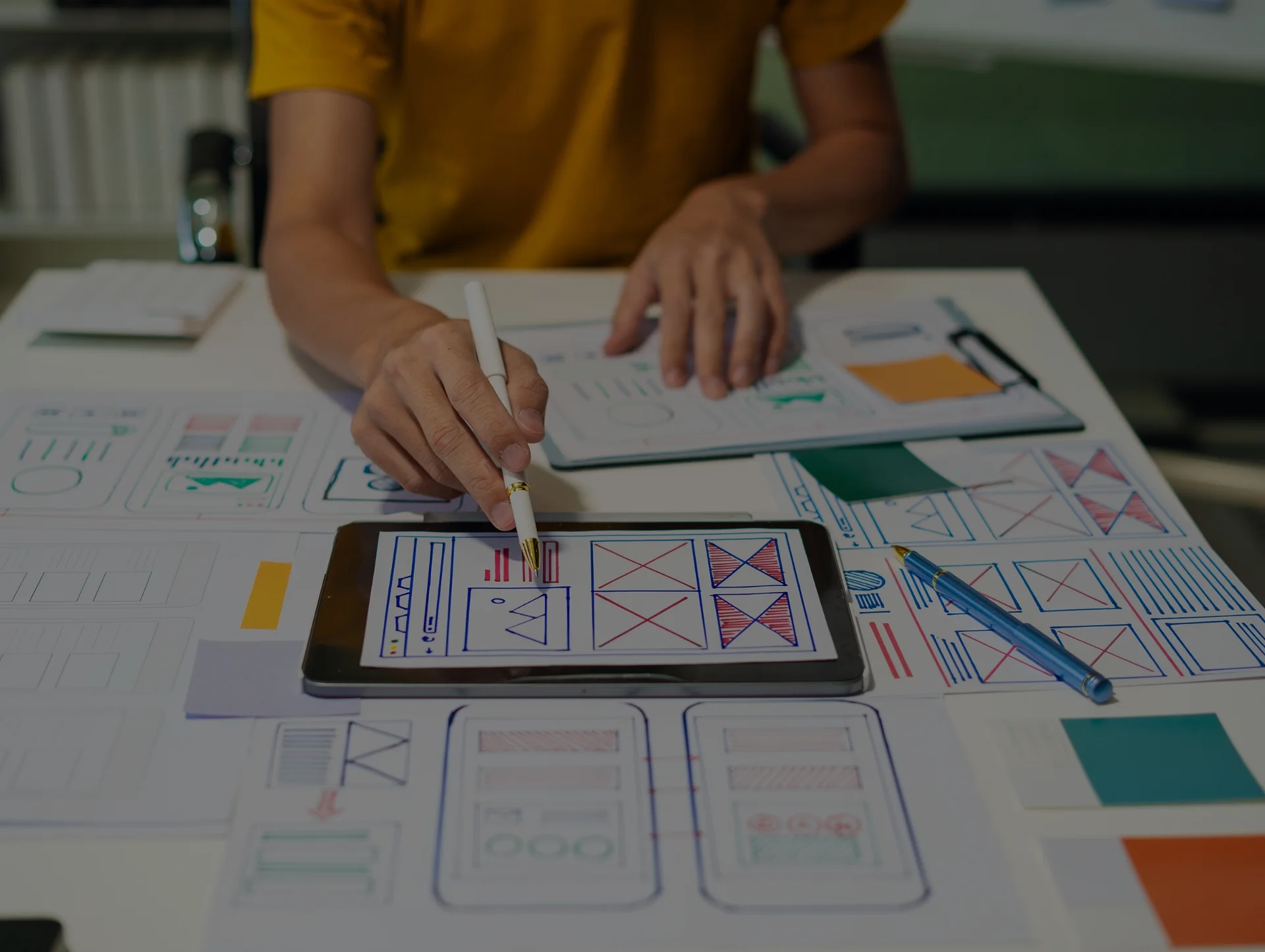 UI/UX Audit services being performed with a tablet displaying wireframe designs. Get a closer look at ui ux audit services to refine your user interface and experience