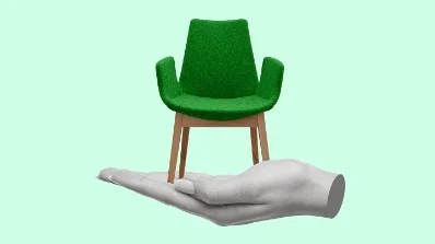 Offline Print Design Services featuring a creative visual of a green chair balanced on a hand, symbolizing the precision of print design solutions