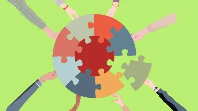 Hands assembling puzzle pieces, symbolizing collaboration in PIM Implementation Services and PIM implementation consultancy